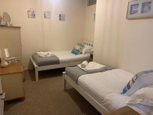 Cette chambre comprend 2 lits et un miroir. dans l'établissement Seawards 2 bedroomed Seafront Filey, à Filey