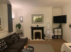 - un salon avec un arbre de Noël et un canapé dans l'établissement Seawards 2 bedroomed Seafront Filey, à Filey