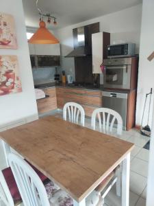 a kitchen with a wooden table and chairs at Chalupa Miška in Gôtovany