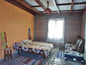 a bedroom with a bed and a window and a couch at CASABLANCA in El Ceibal