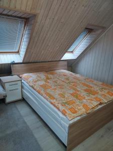 ein Schlafzimmer mit einem Bett in einem Zimmer mit Oberlichtern in der Unterkunft Chalupa Miška in Gôtovany