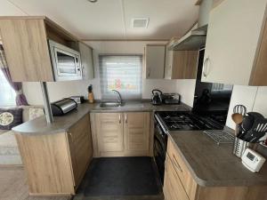 a small kitchen with a sink and a stove at 'Oakley' Boat of Garten Holiday Park in Boat of Garten