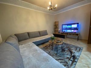 a living room with a couch and a tv at Lucas Apartment 2 in Tirana