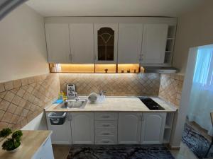 a small kitchen with white cabinets and a sink at Lucas Apartment 2 in Tirana