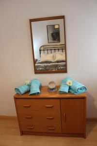 a dresser with two blue pillows and a mirror at El Refugio in Calatayud