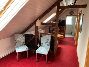 ein Zimmer mit einem Tisch und Stühlen im Dachgeschoss in der Unterkunft Ferienwohnung Buchenblick in Kassel