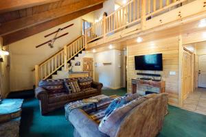 uma sala de estar com um sofá e uma televisão em Yosemite Silvertip Lodge em Fish Camp