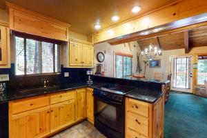 a large kitchen with wooden cabinets and black counter tops at Yosemite Silvertip Lodge in Fish Camp +14 photos