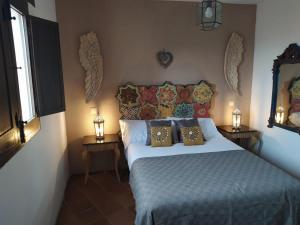 a bedroom with a bed with pillows and a mirror at Spa La Cueva del Agua in Hita