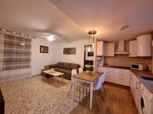 a kitchen and living room with a table and a couch at Vivienda Turística en la Muralla de San Basilio in Córdoba