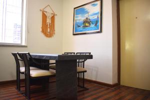 stół jadalny z krzesłami i obraz statku w obiekcie Casa do Sol Fortaleza w mieście Fortaleza