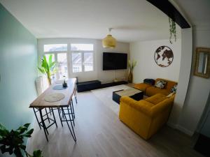 uma sala de estar com um sofá amarelo e uma mesa em Charming & cosy rooms Nantes (chambres chez l'habitant) em Nantes