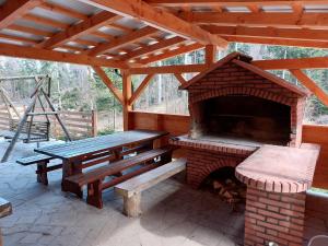 un patio con mesa de picnic y horno de ladrillo en Holiday home Polsak, en Planina