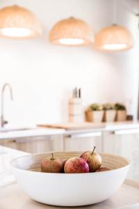 a bowl of apples on a counter in a kitchen at Beach House Pedras D'el Rei in Santa Luzia