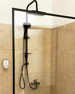 a shower with a shower head in a bathroom at Hotel Ambasador in Lezhë