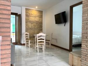 - une salle à manger avec une table, des chaises et une télévision dans l'établissement La Casa de La Escalera, à Cordoue
