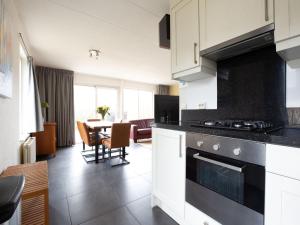 a kitchen with a stove and a dining room at Holiday Home in De Koog near Texel Beaches in De Koog