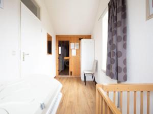 a bedroom with a bed and a chair in a room at Holiday Home in De Koog near Texel Beaches in De Koog