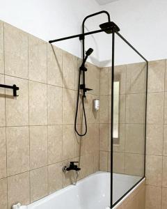 y baño con ducha y bañera. en Hotel Ambasador Garden, en Lezhë