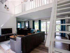 a living room with a large couch and a table at Spacious house with covered terrace, located on a holiday park in Rhenen in Rhenen