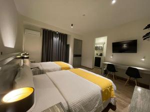 a hotel room with two beds and a flat screen tv at Capital Suites in Chilpancingo 