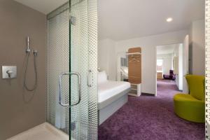ein Bad mit einer Dusche und ein Schlafzimmer mit einem Bett in der Unterkunft YOTEL Boston in Boston