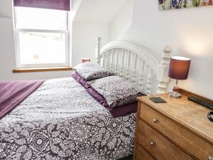 a bedroom with a bed and a desk with a lamp at Bodfan Peniel in Llanerchymedd