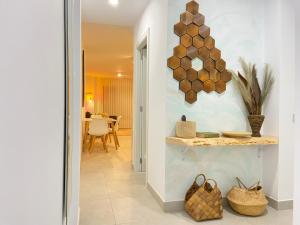 un pasillo de una casa con una mesa con cestas en Viuter - Magna Home las Canteras Beach + Parking, en Las Palmas de Gran Canaria