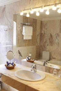 bagno con lavandino e specchio di Hotel Can Ceret a Sant Pere Pescador