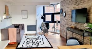 a living room with a brick wall at Hounds Gate Luxury Apartments by 1508 Stays in Nottingham