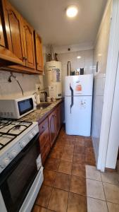 a kitchen with a white refrigerator and a stove at NO ME OLVIDES in Mendoza