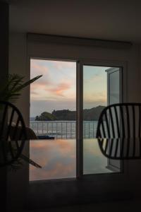 eine Glastür mit Blick auf das Wasser in der Unterkunft Casa Maria do Ilhéu in Vila Franca do Campo