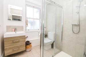 a bathroom with a shower and a sink and a toilet at Cool Stone Cottage in Instow +21 photos