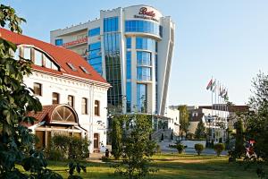 a large building with a red roof in a city at Boutique Hotel Buta in Minsk