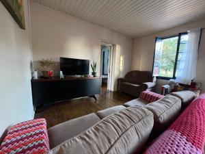 a living room with a couch and a flat screen tv at Casa Foresti in Bento Gonçalves