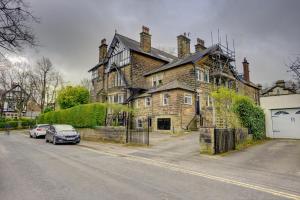 an old house with cars parked in front of it at Kist Accommodates - The Woodlands in Harrogate