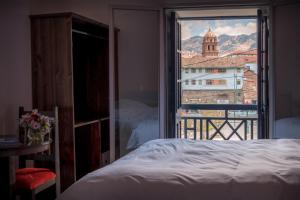 Un dormitorio con vista a una ciudad desde una ventana. en Hotel Limacpampa, en Cusco 44 fotos más