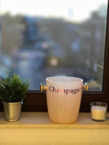a coffee cup sitting on a window sill with a potted plant at Schickes Apartment mit Balkon in Düsseldorf in Düsseldorf