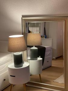 1 dormitorio con espejo, 2 lámparas y 1 cama en Schickes Apartment mit Balkon in Düsseldorf en Düsseldorf