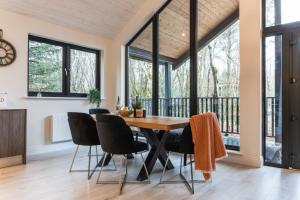 a dining room with a wooden table and black chairs at Drumhierny Woodland Hideaway in Leitrim