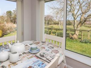 a dining room with a table and a window at Crud Yr Awel in Amlwch