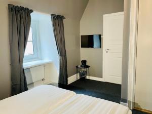a bedroom with a bed and a window and a television at Birka Hotel in Stockholm