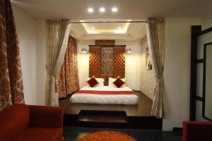 Habitación de hotel con cama y sofá en Hotel Saffron Leaf, en Dehradun