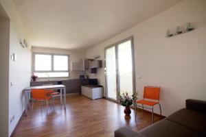 a living room with a kitchen and a table and chairs at Residence Le Querce in Cernusco sul Naviglio