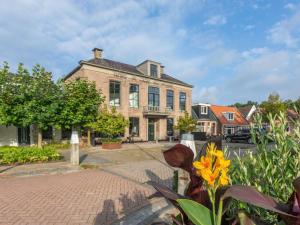 una casa grande con una entrada de ladrillo delante de ella en Group accommodation at unique location in Friesland, en Ternaard