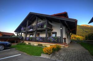 ein Haus mit Blumen auf dem Balkon in der Unterkunft Haus Himmelreich in Hirschegg