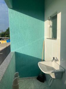 ein Badezimmer mit einem weißen Waschbecken und einer blauen Wand in der Unterkunft Aconchego Meu in Cabo Frio