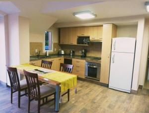 a kitchen with a table and a white refrigerator at Civico Apartment in San Carlos de Bariloche