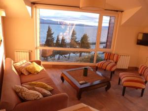 een woonkamer met een bank en een groot raam bij Civico Apartment in Bariloche