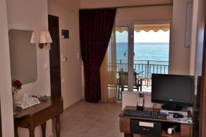 a living room with a computer and a view of the ocean at Corali Studios in Palaiochora